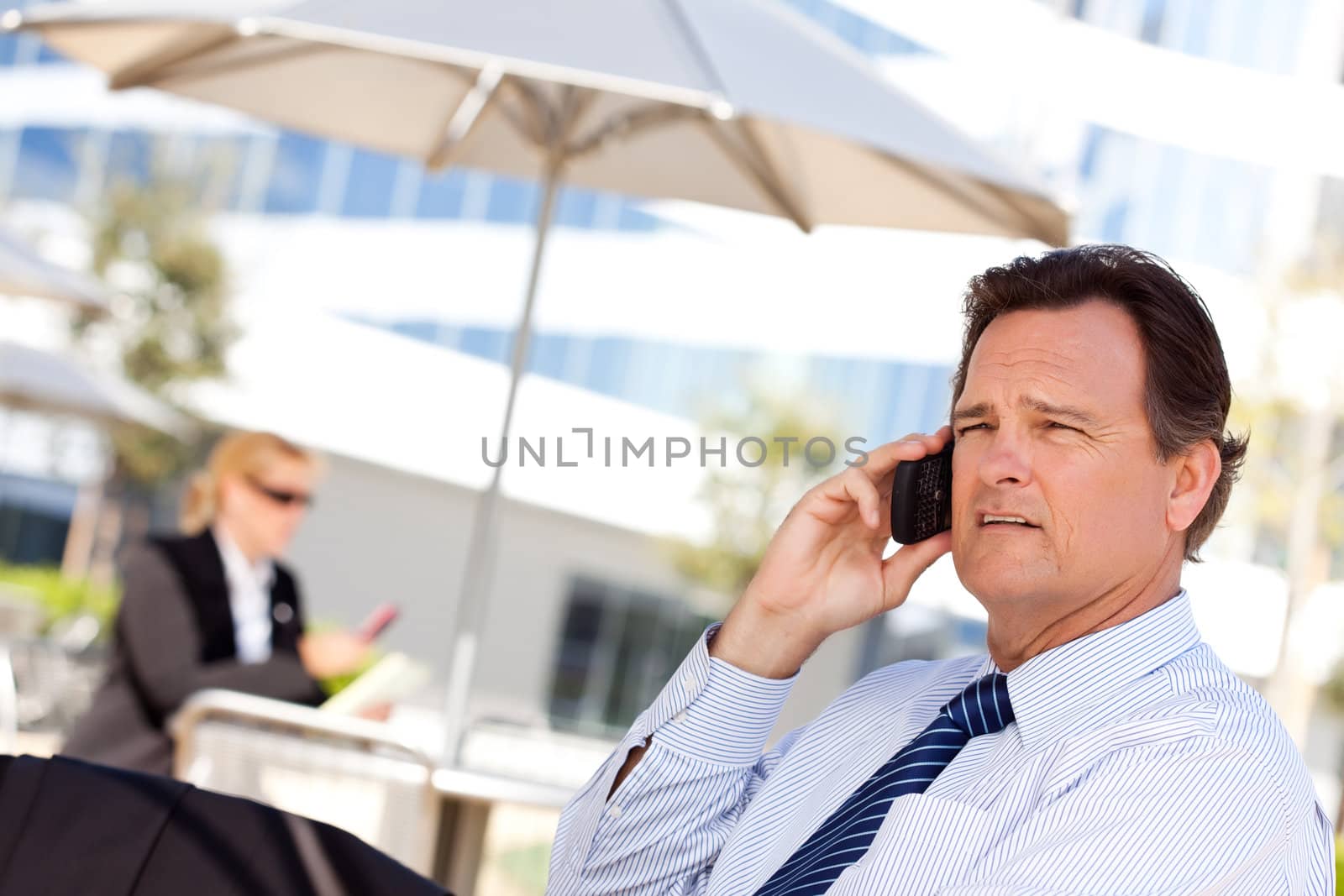 Confident, Handsome Businessman Smiles as He Talks on His Cell Phone.