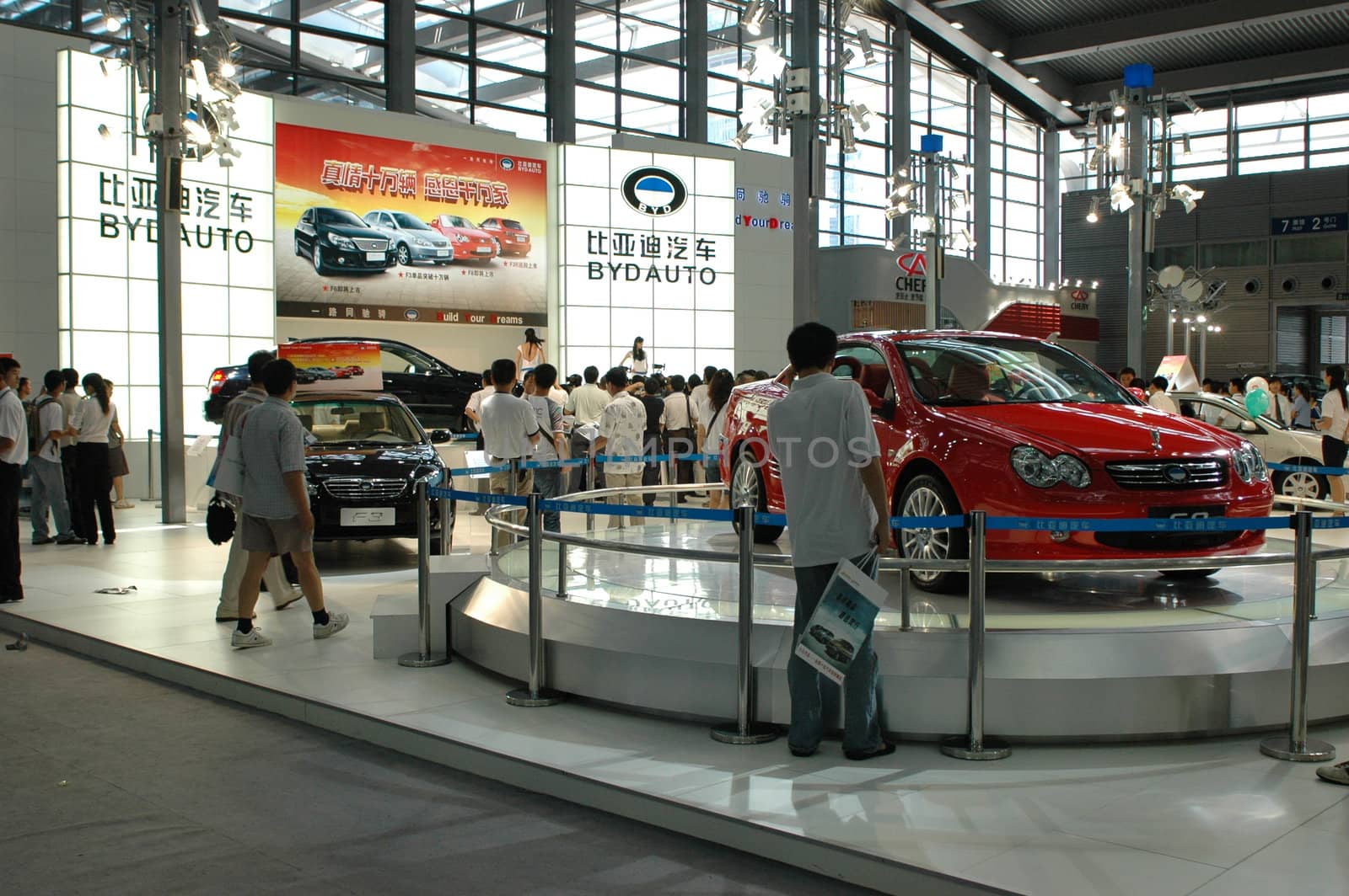 China, Shenzhen Moto - car show in exhibition center. Visitors watching European, American and Chinese cars. Crowd of people interested in newest moto technology.