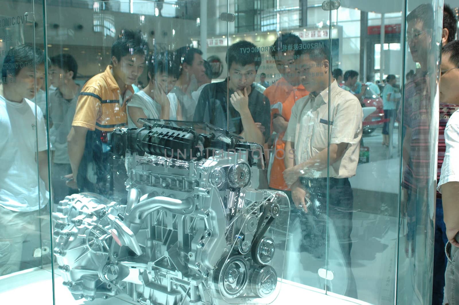 China, Shenzhen Moto - car show in exhibition center. Visitors watching European, American and Chinese cars. Crowd of people interested in newest moto technology.