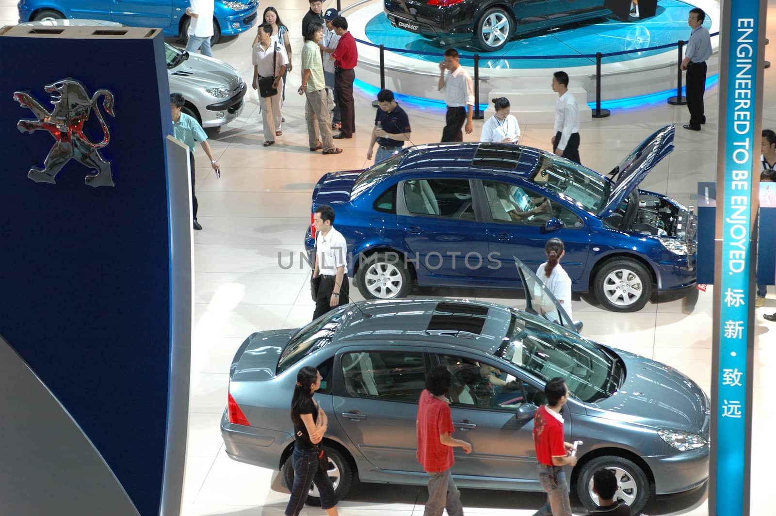 China, Shenzhen Moto - car show in exhibition center. Visitors watching European, American and Chinese cars. Crowd of people interested in newest moto technology.