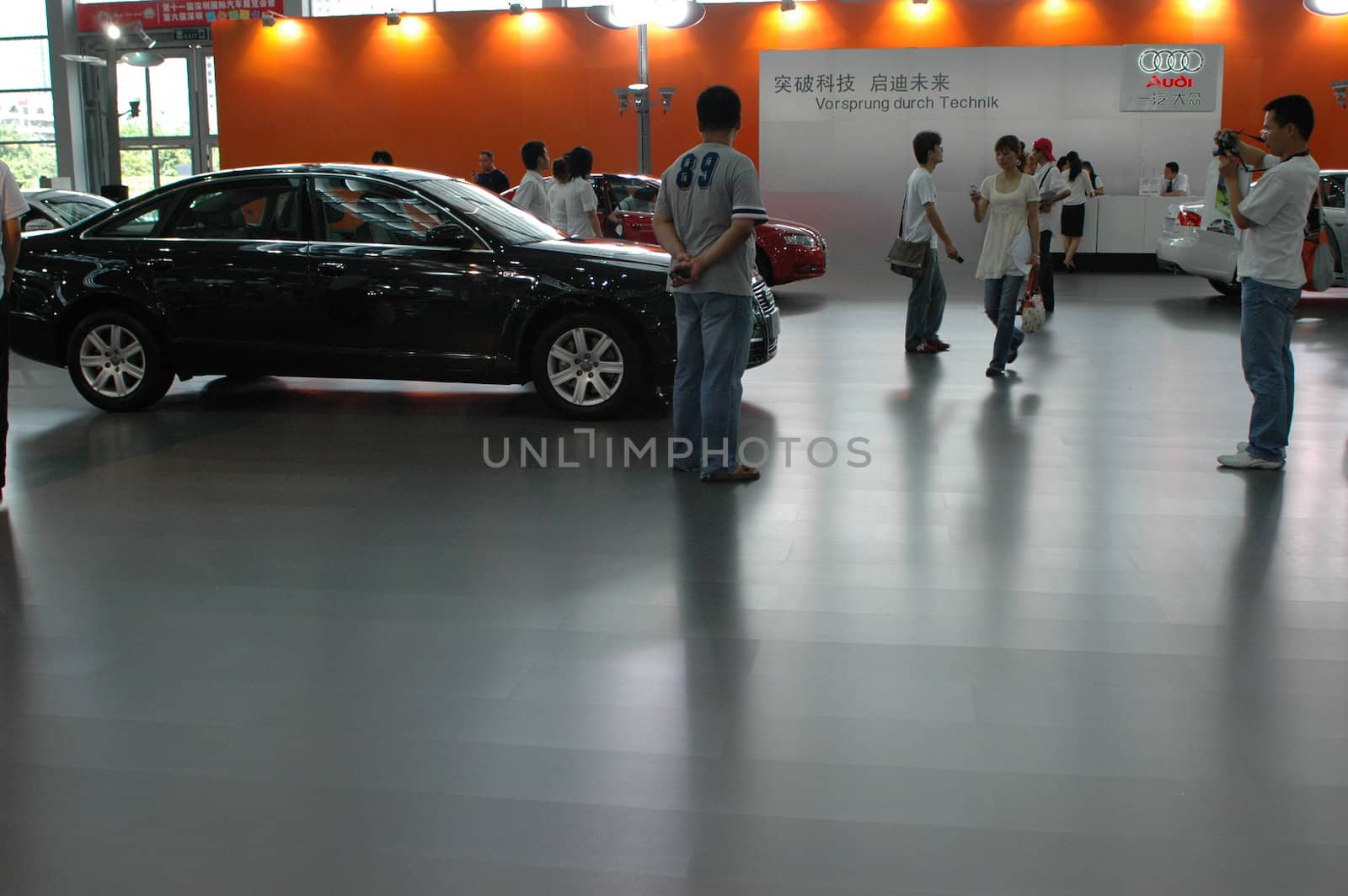 China, Shenzhen Moto - car show in exhibition center. Visitors watching European, American and Chinese cars. Crowd of people interested in newest moto technology.