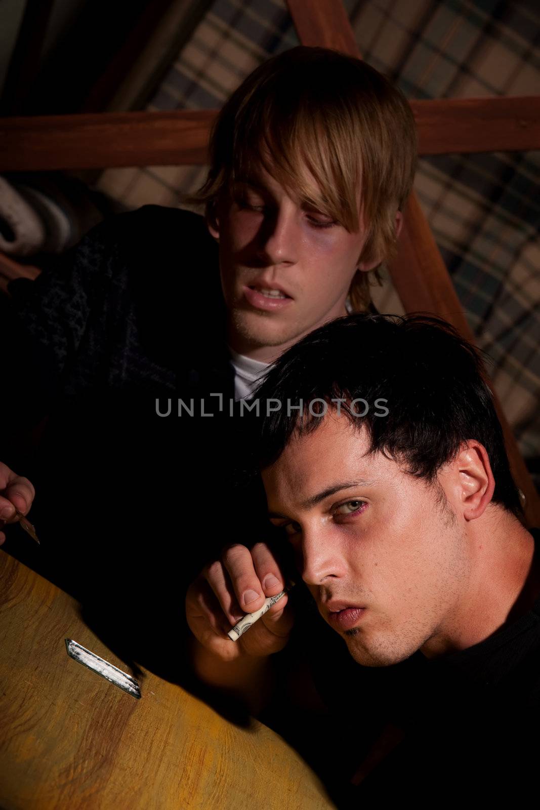 Two young men with heroin or cocaine on table
