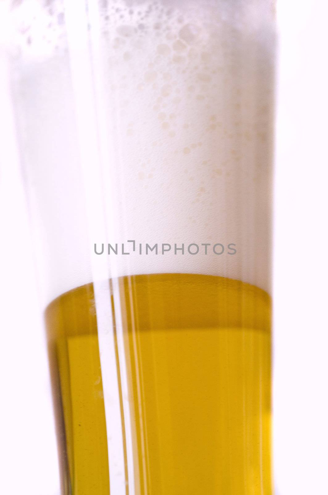close-up on a glass of foamy fresh blonde beer, isolated on white