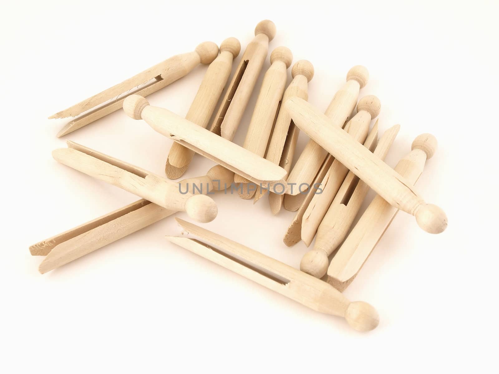 A pile of old fashioned clothespins isolated on a white background.