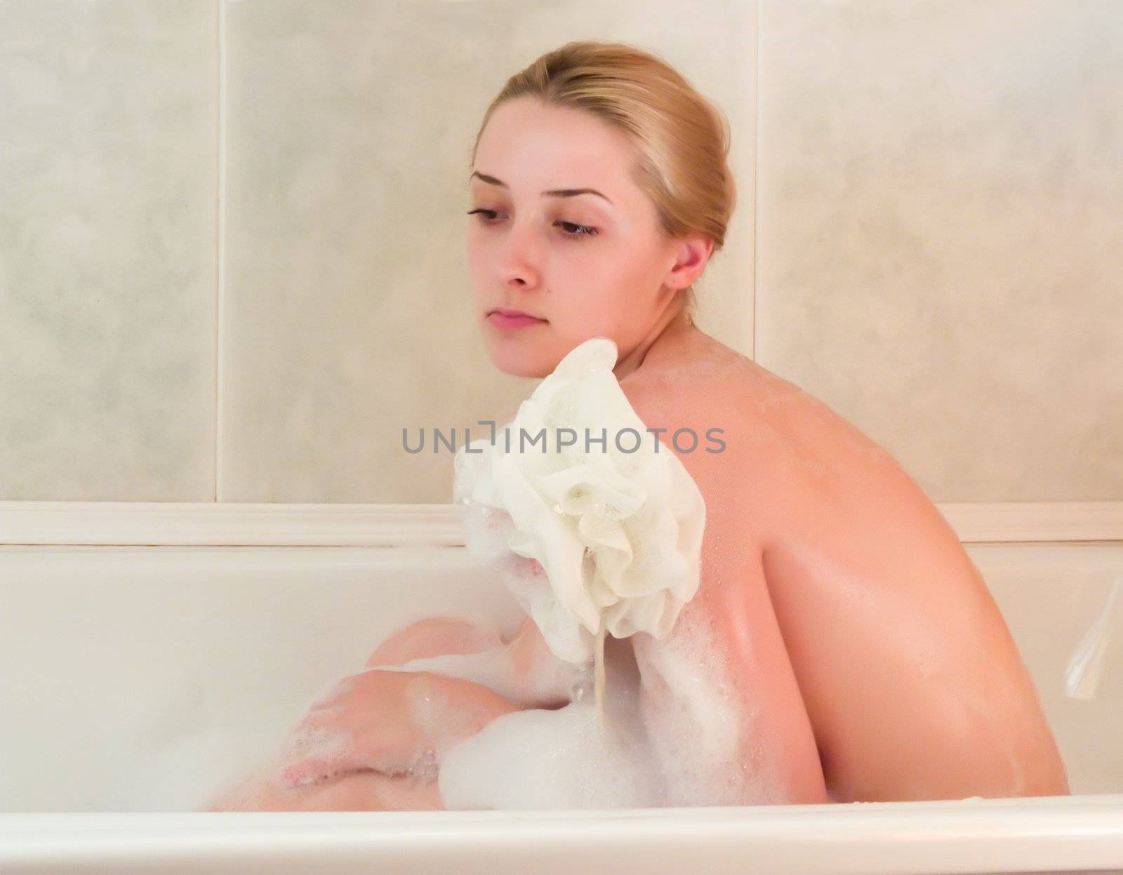 young beautiful girl in a bath with shower