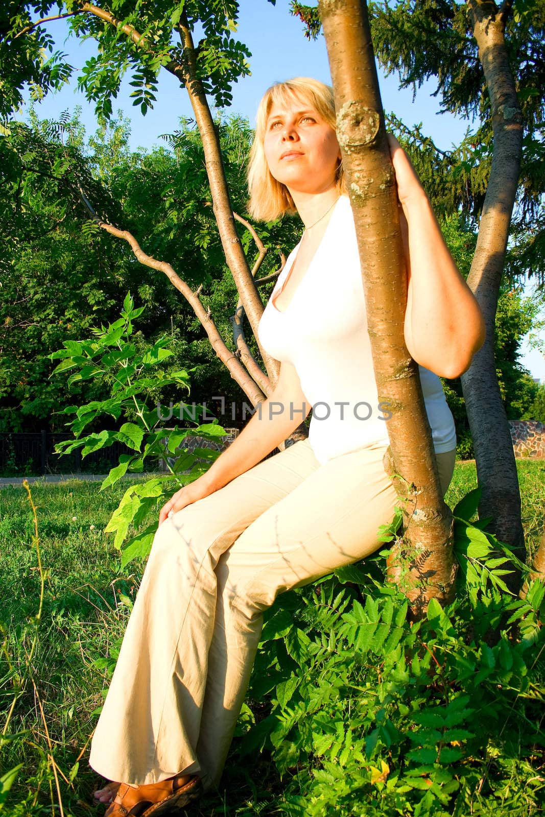 woman in light clothes against green trees