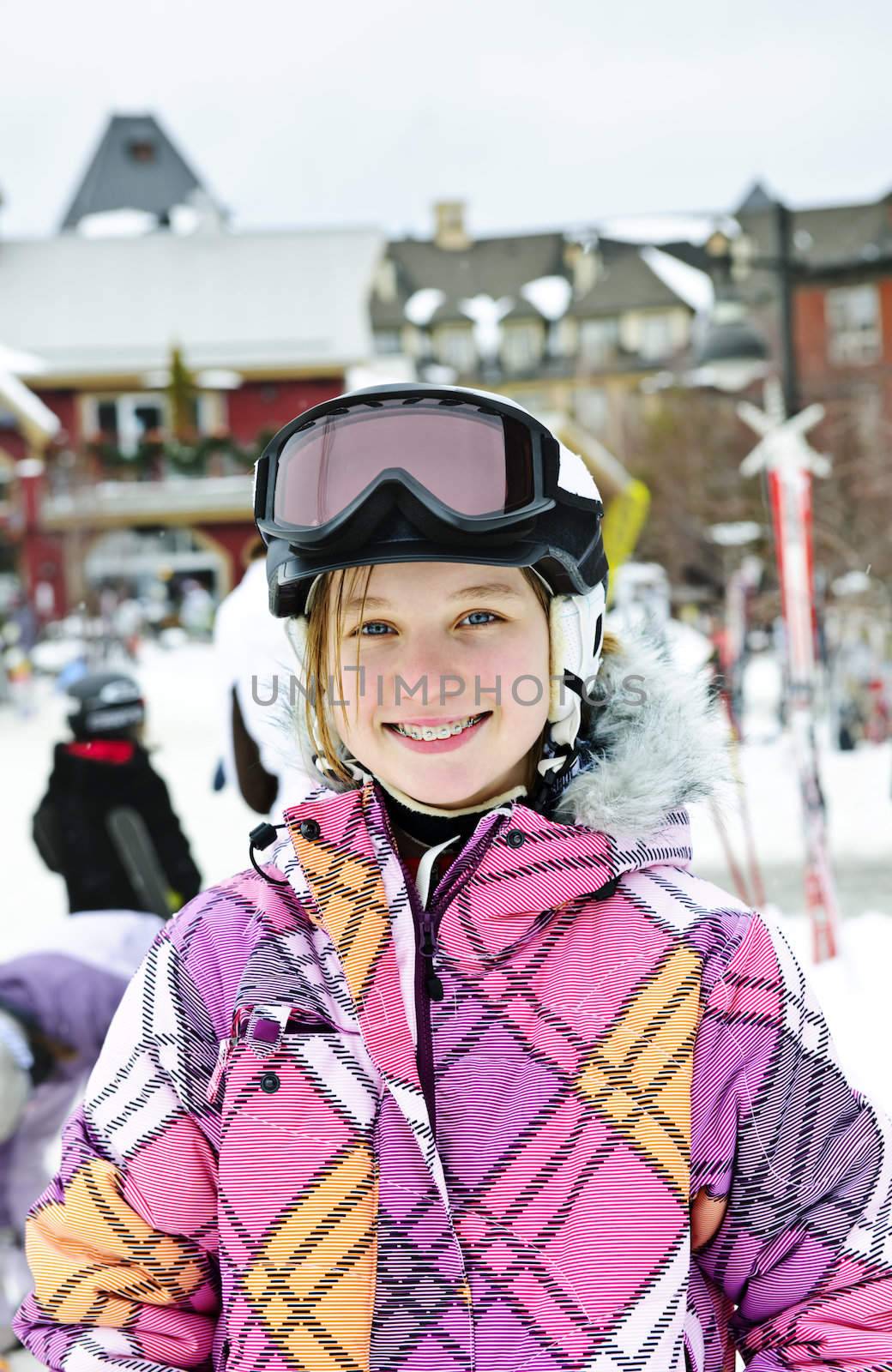 Portrait of happy teenage girl in ski helmet and goggles at winter resort