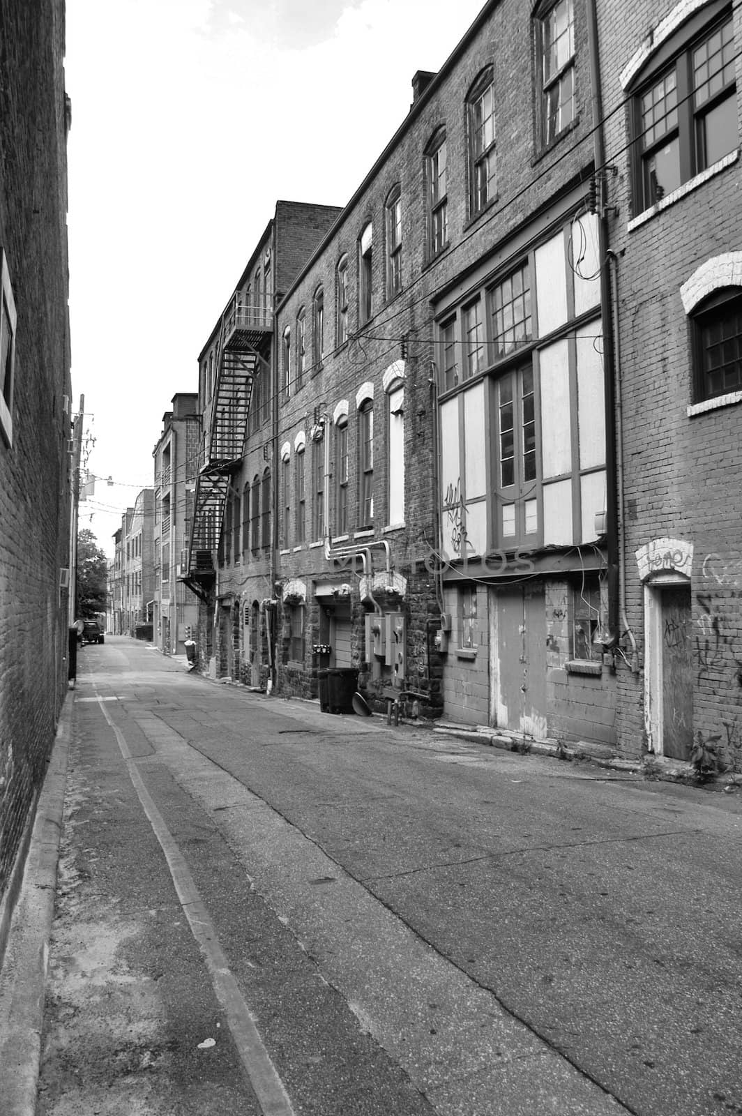 A view of a back alley in a southern town. Shown in black and white