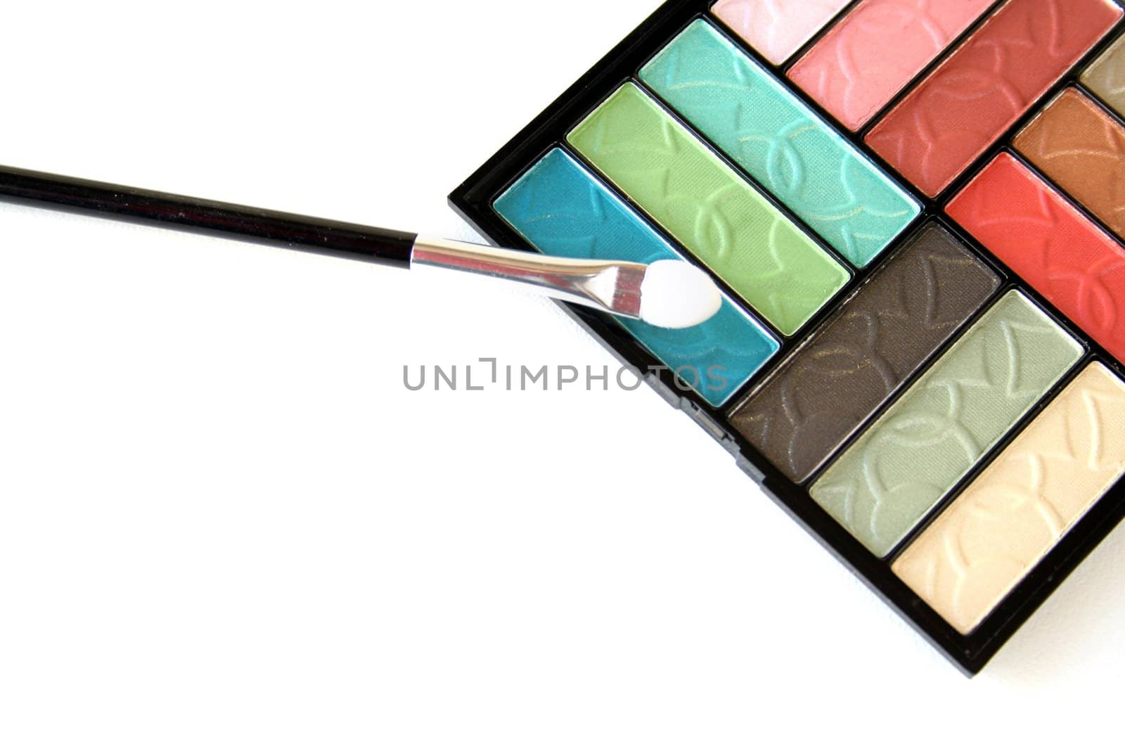 colorful eye shadows and brush isolated on a white background.


