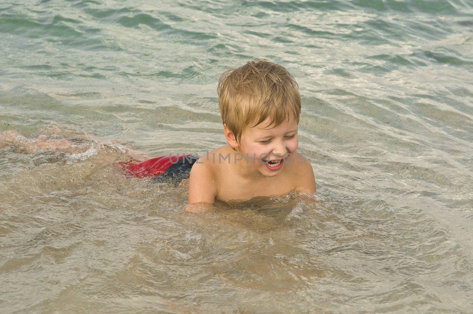 Summer, sun, good weather, a boy swimming in the sea