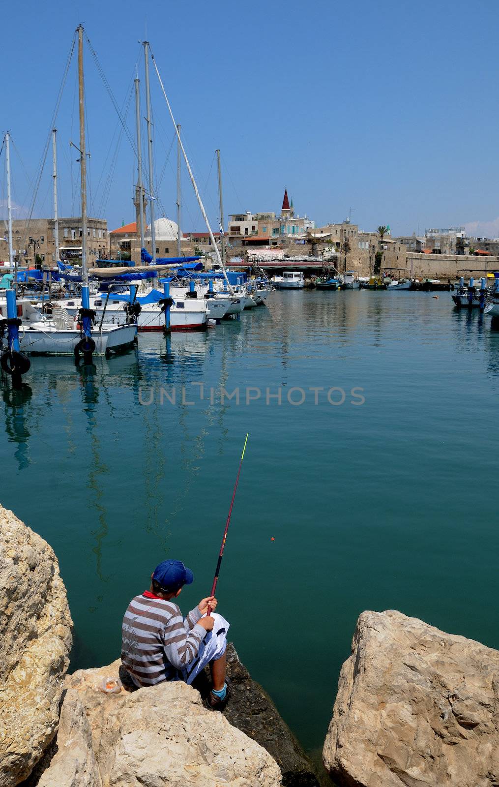 The boy catches fish in the bay