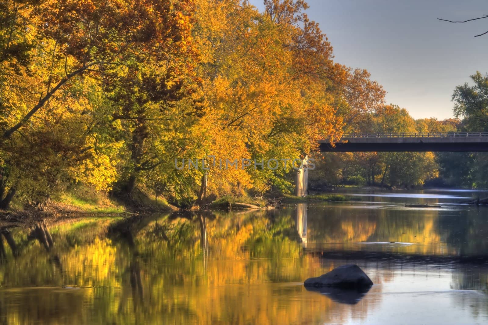 A river flows by fall colored trees