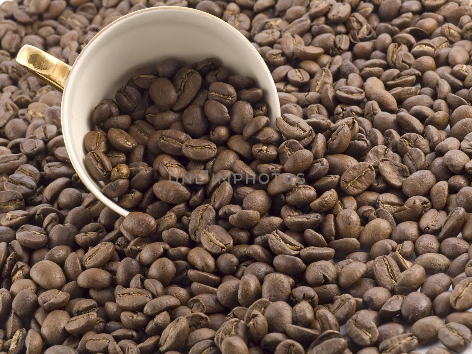 coffee cup full of coffee beans on dark background