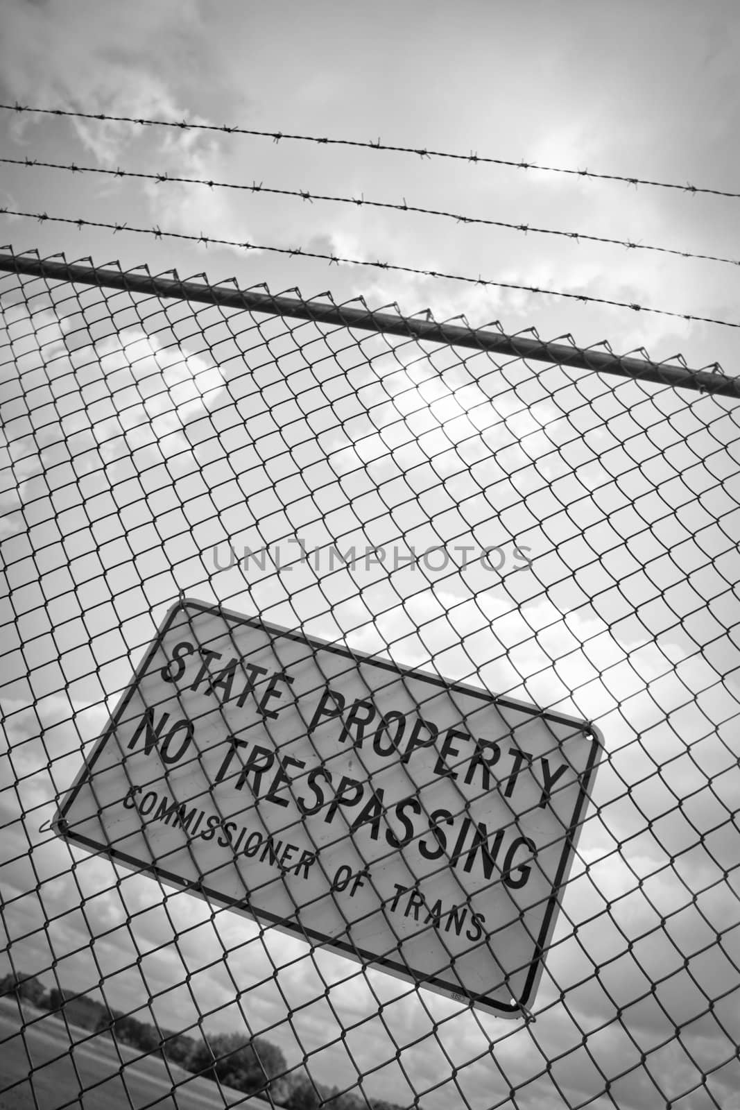A no trespassing sign that reads STATE PROPERTY NO TRESPASSING outside an airport.