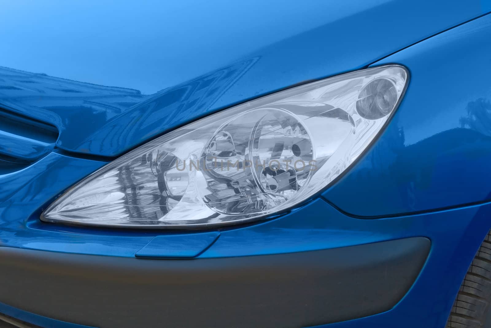 The headlight of a blue modern car