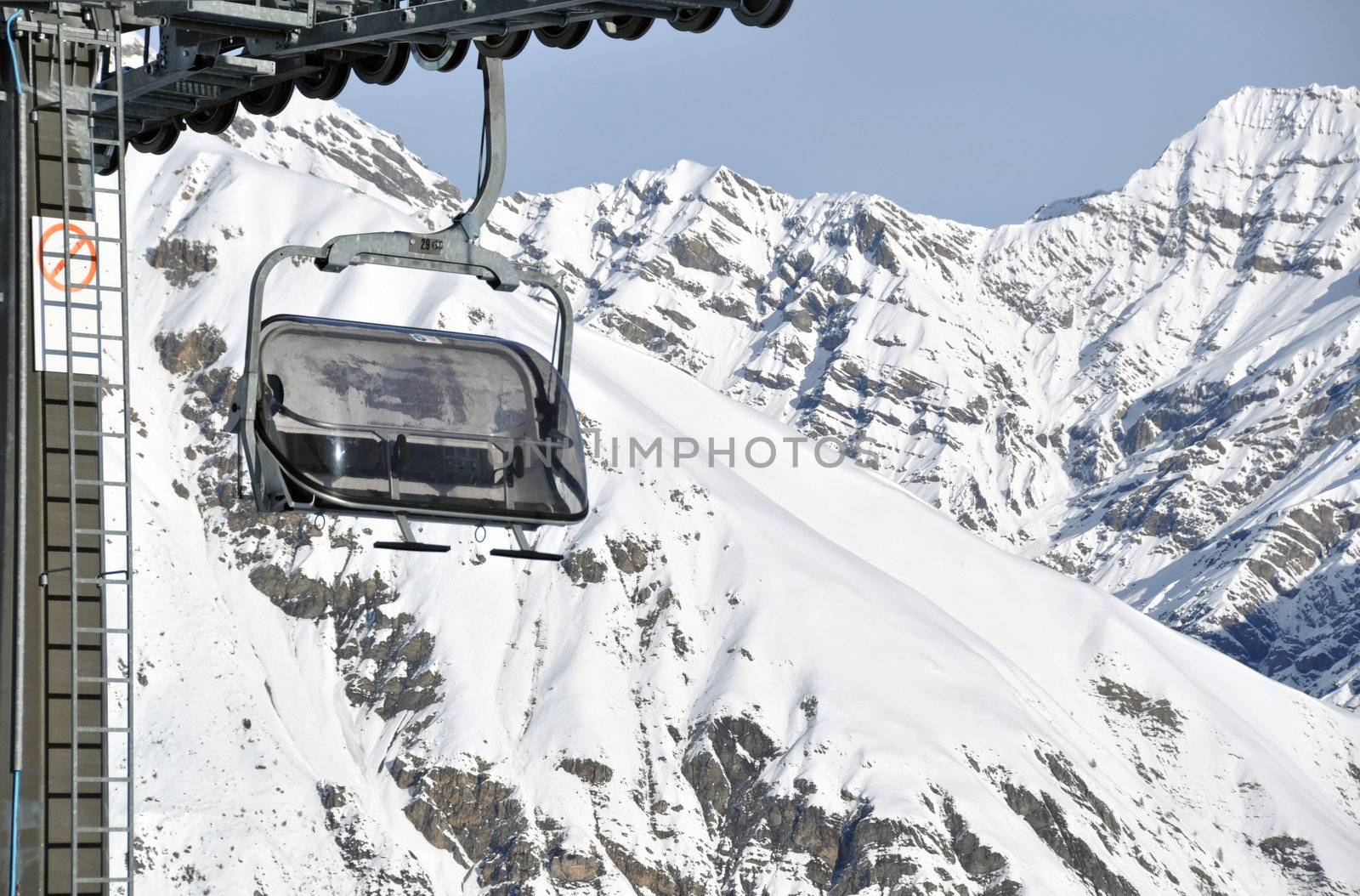 Chairlift with impressive mountains in the background - shot in Livigno, Italian Alps