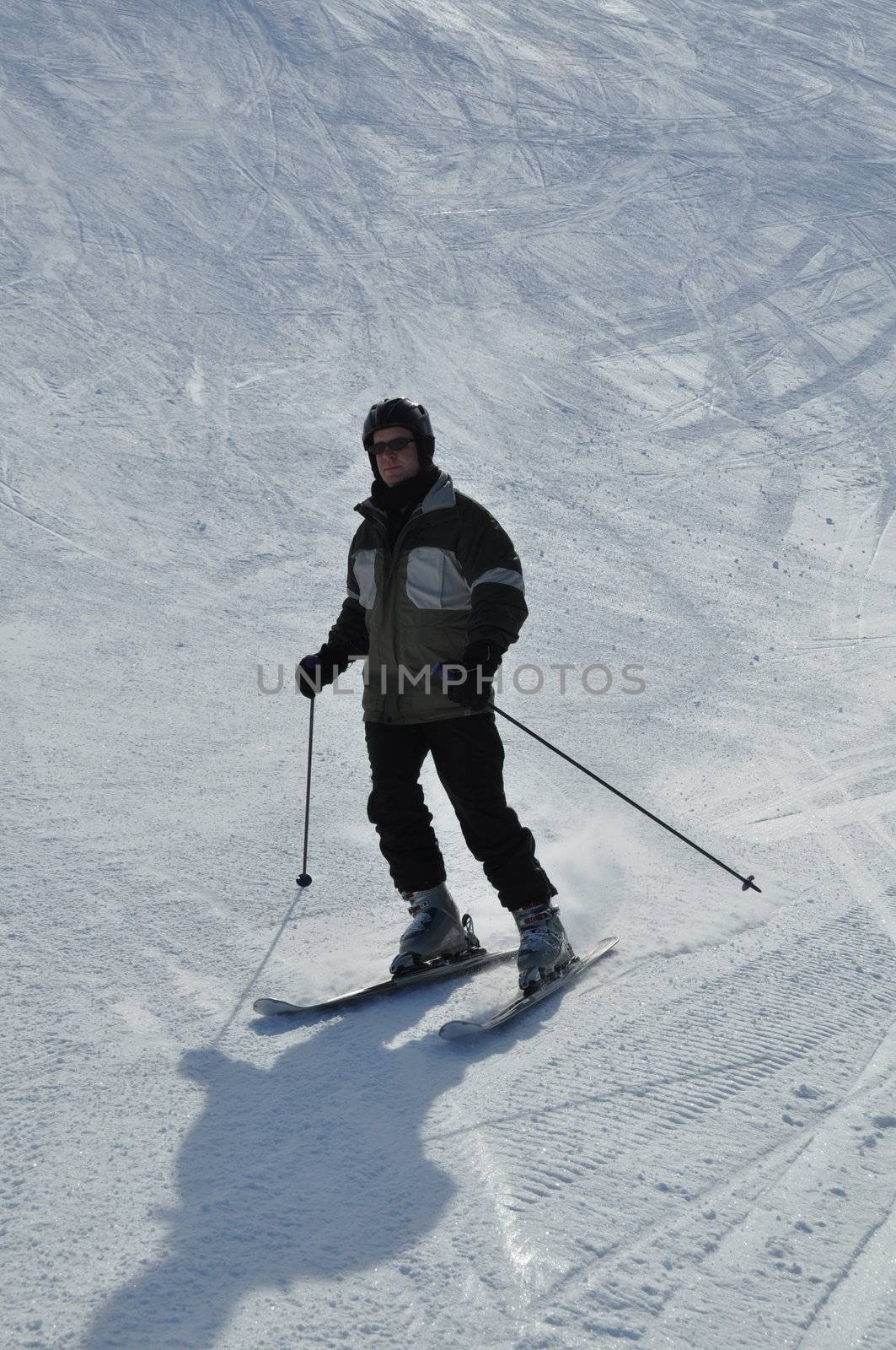 Middle aged skier wearing helmet in powder snow on steep hill - shot in Livigno, Italian Alps