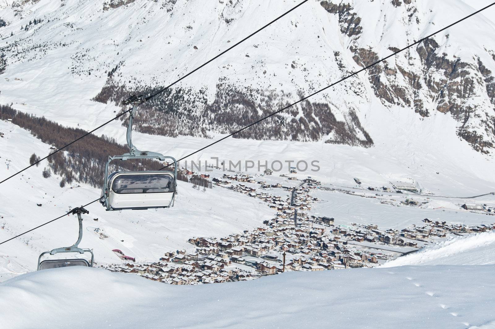 Chairlifts running above a mountain village - shot in Livigno, Italian Alps