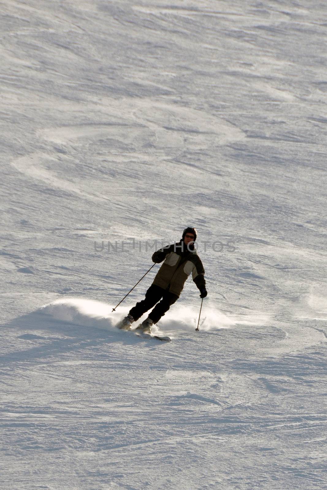 Middle aged female snowboarder wearing helmet and snow goggles in powder snow on steep hill - shot in Livigno, Italian Alps