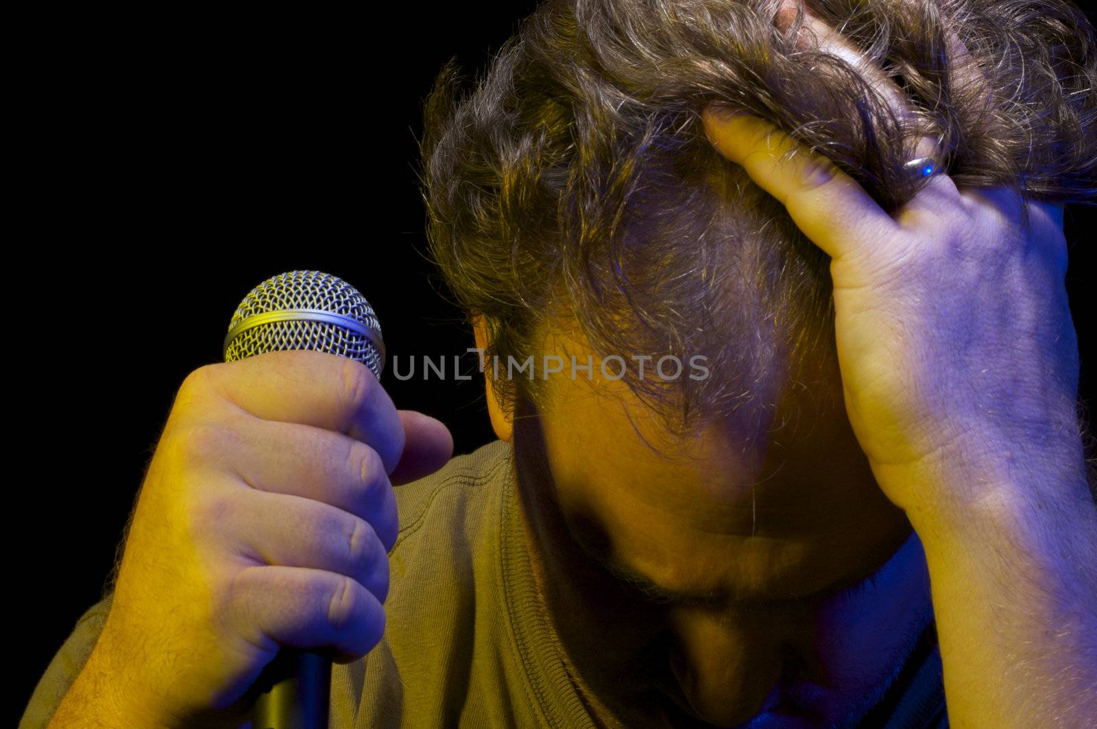 Passionate Vocalist with Microphone on a black background.