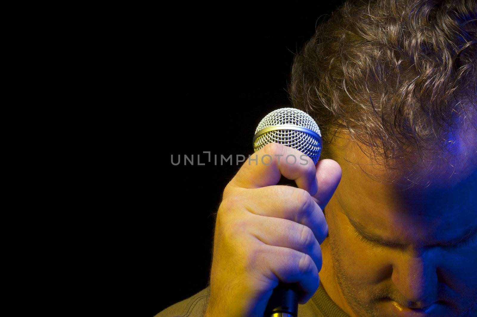 Passionate Vocalist with Microphone on a black background.