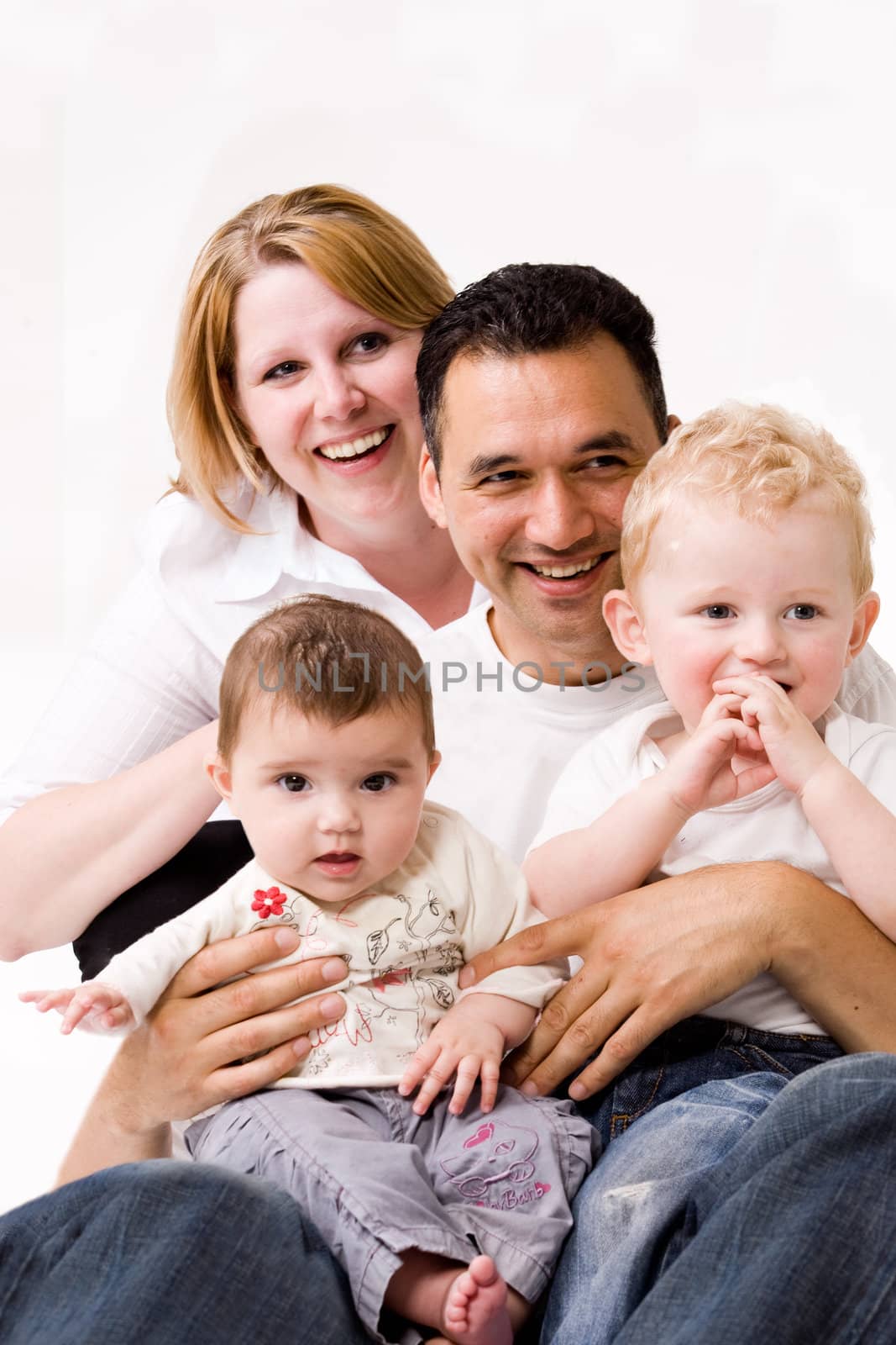 Cute brother and sister from different races having fun with daddy and mom
