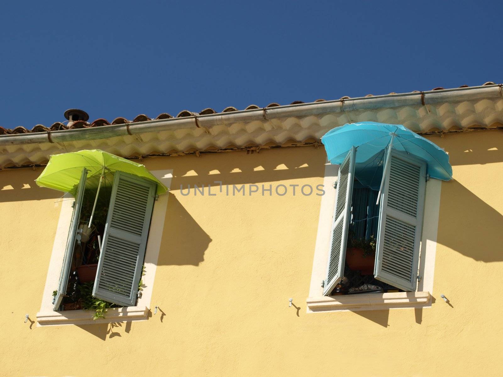 colored umbrellas to protect from sun in a french provence street
