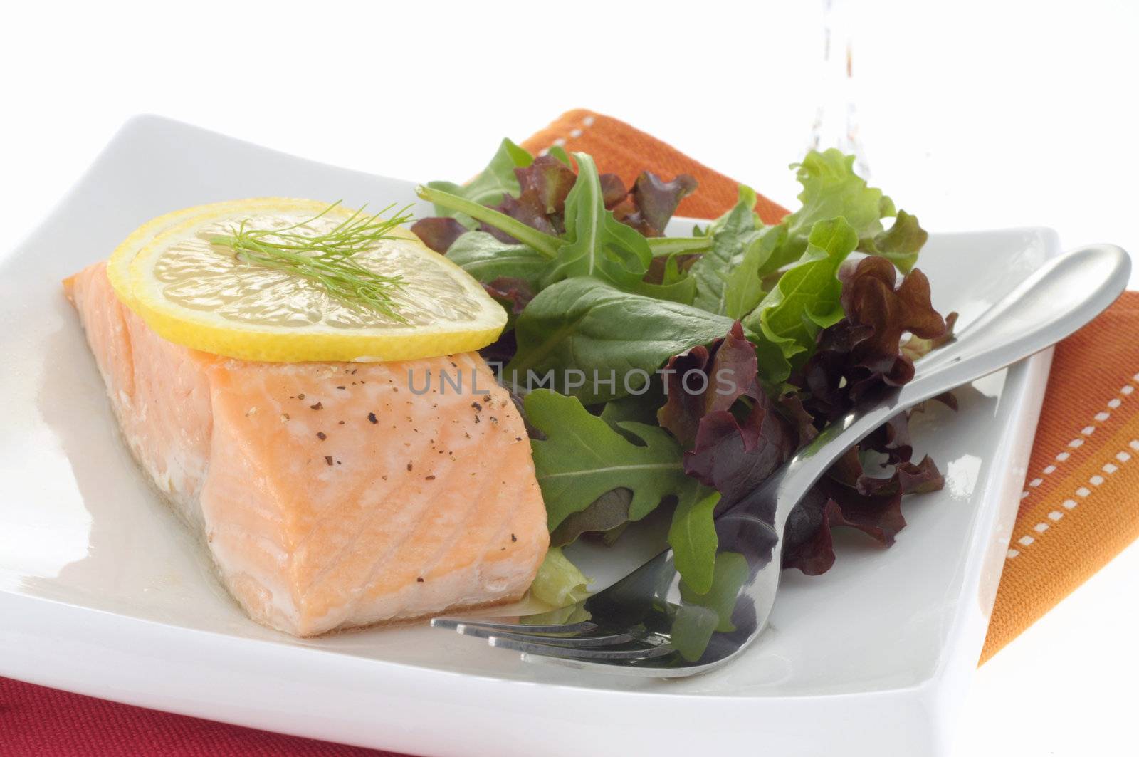 Delicious poached salmon served with greens and lemon.