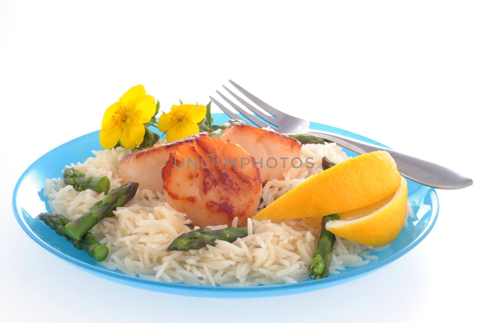 Fresh sea scallops served with rice and lemon.