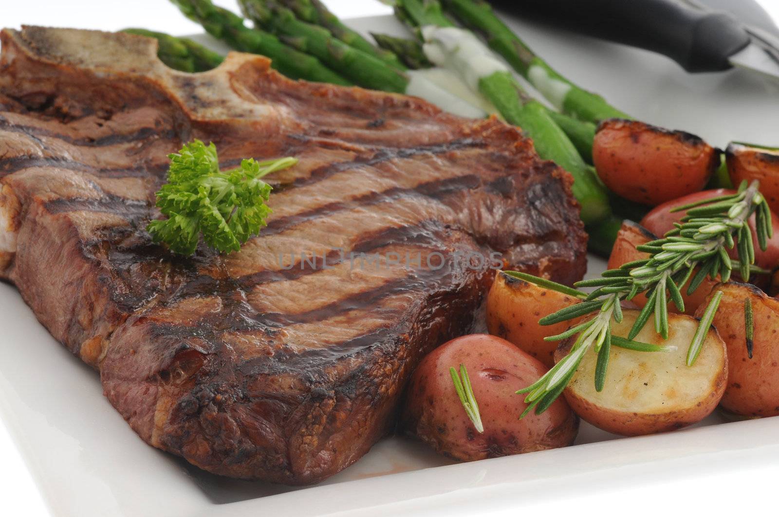 Perfectly grilled t-bone steak with roasted vegetables.
