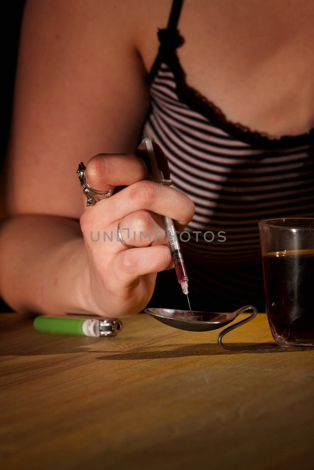 Drawing black tar heroin into a needle by Creatista