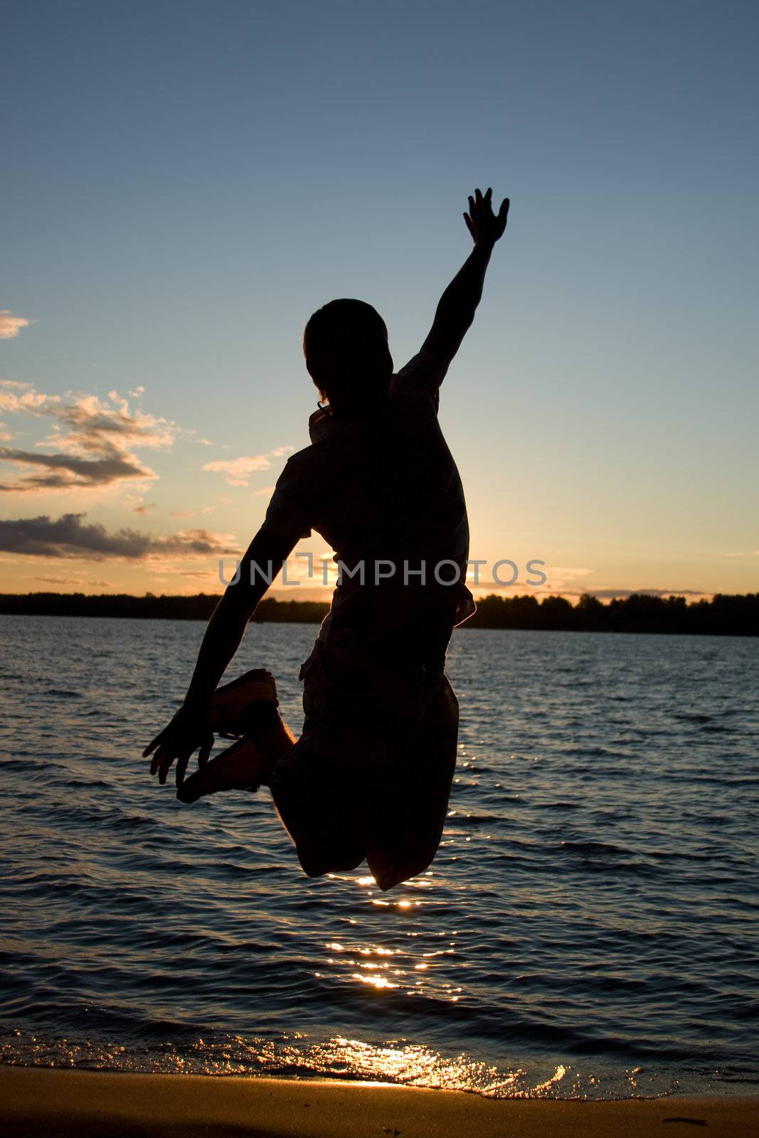 Young man jump over sunlight near the river