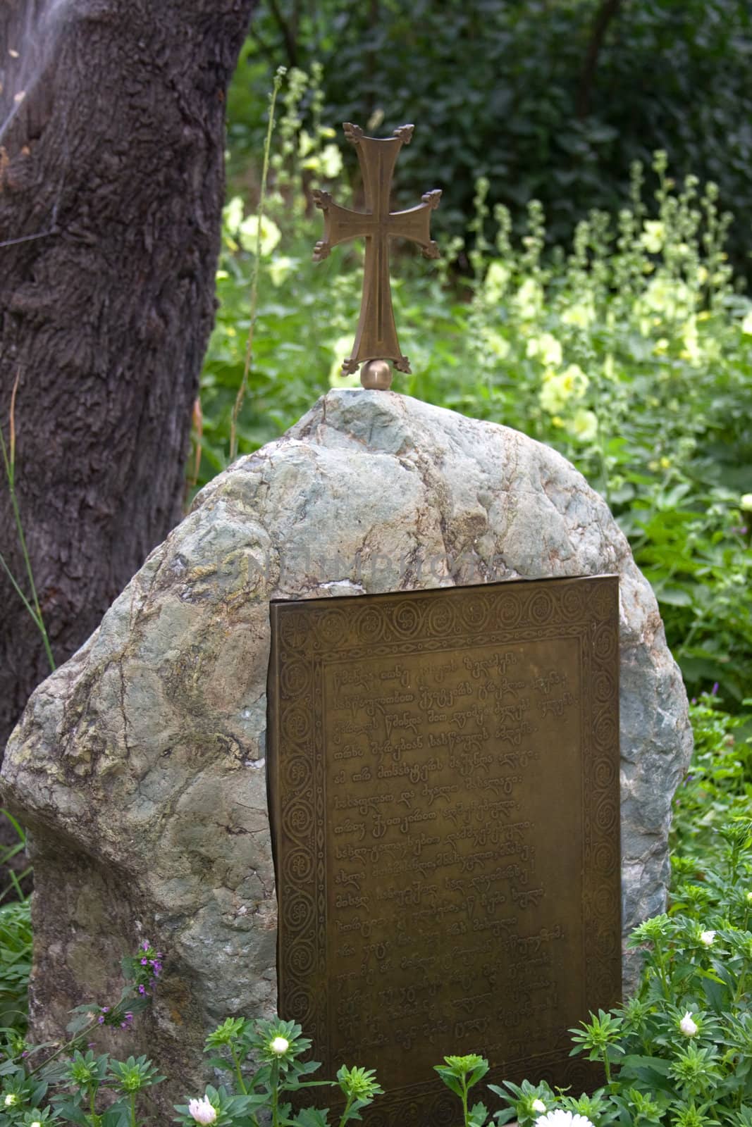Georgian sign on the old gravestone near the tree