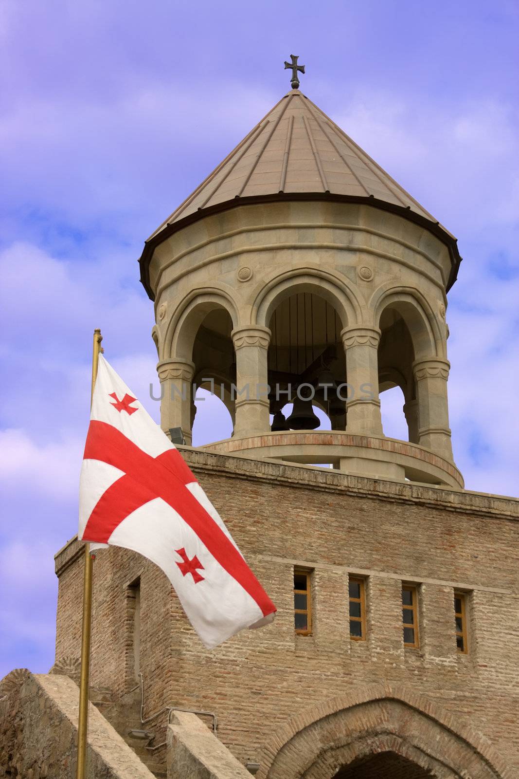 Georgian flag over orthodox monastery with blue sky