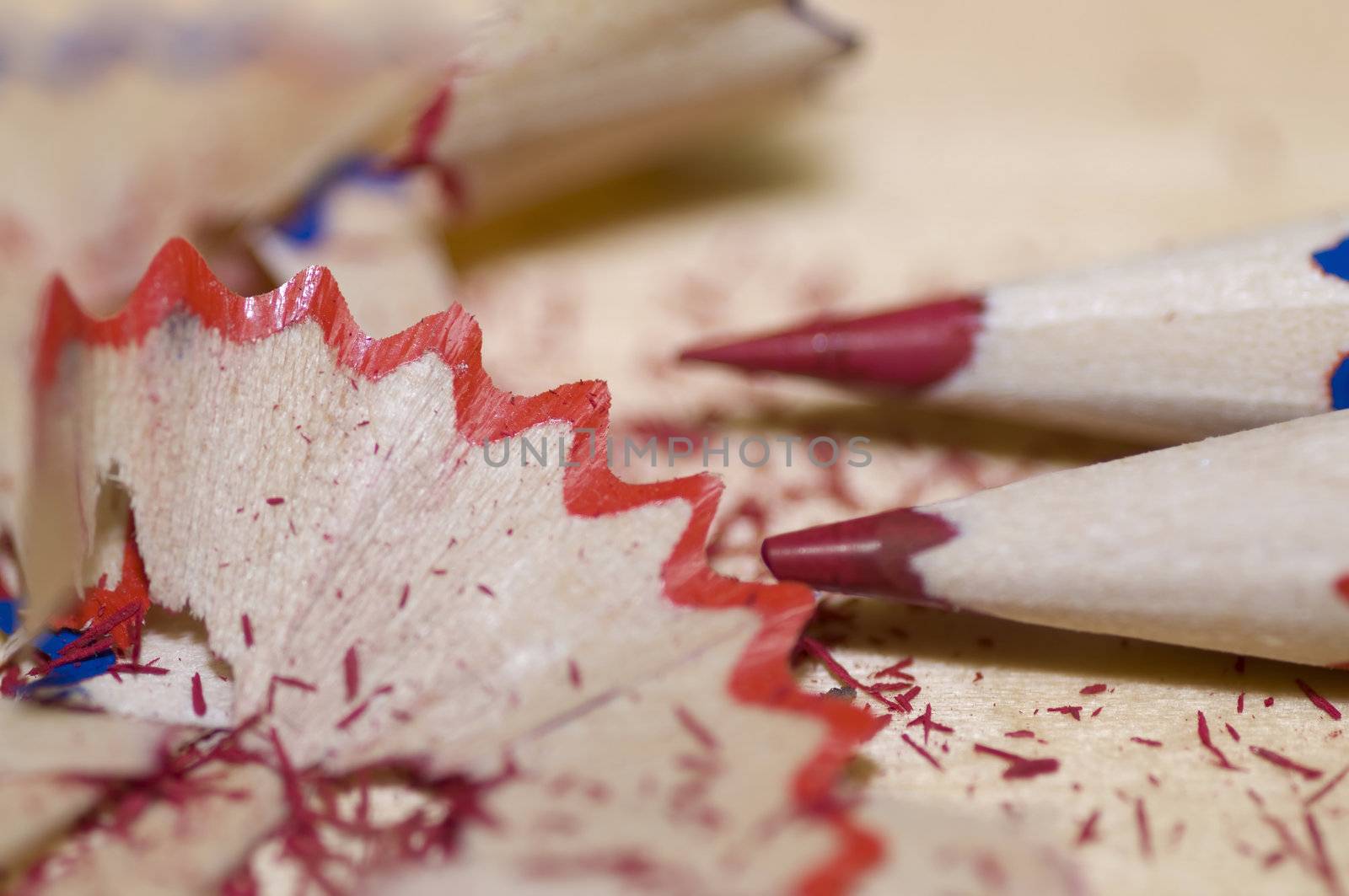 Sharpened pencils and wood shavings, on light color wood background