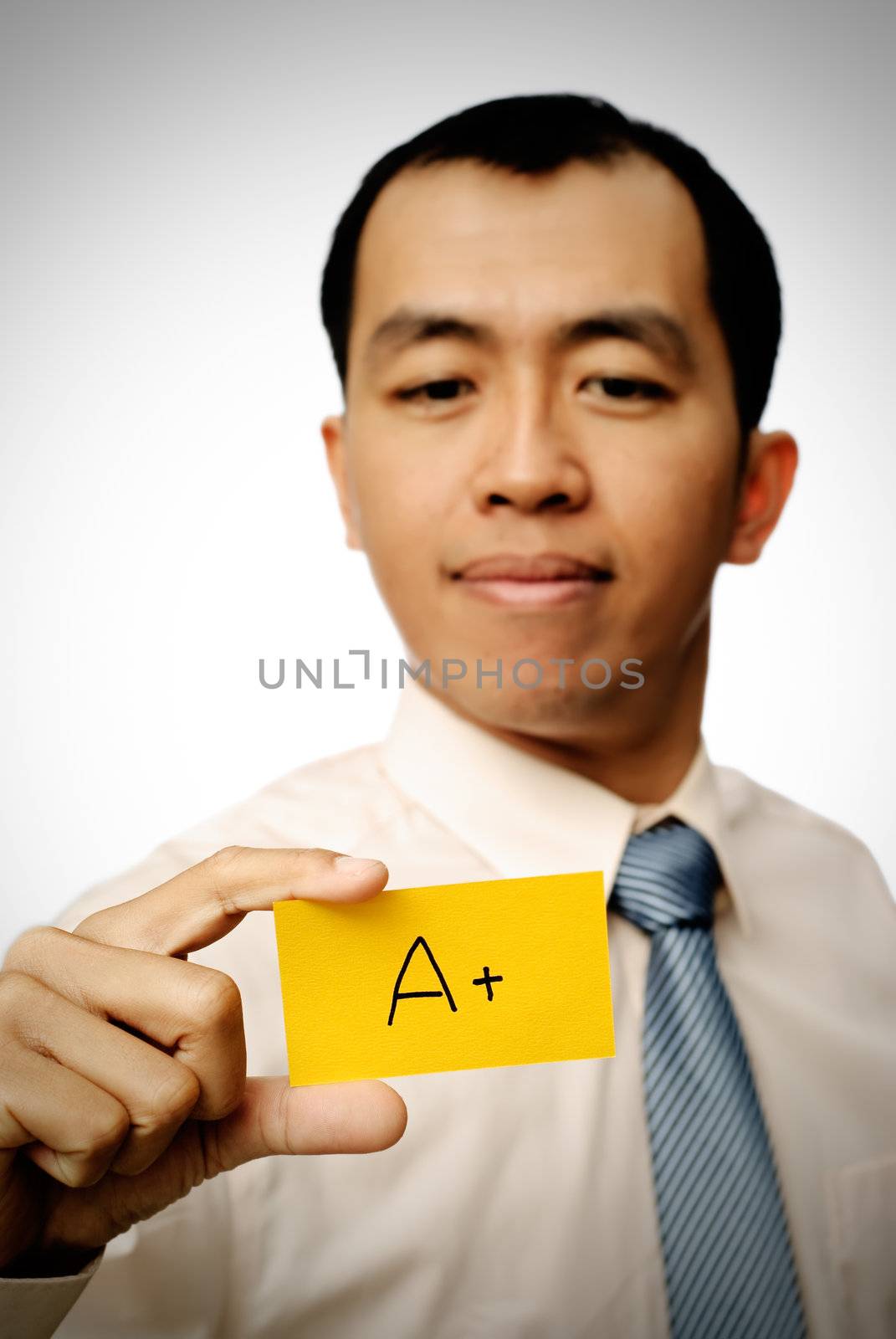 Successful businessman holding A+ card in yellow color.