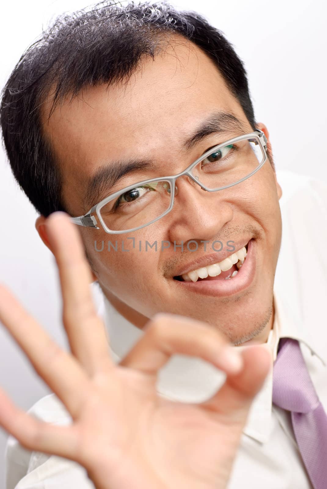 Businessman of Asian showing OK gesture and smiling.