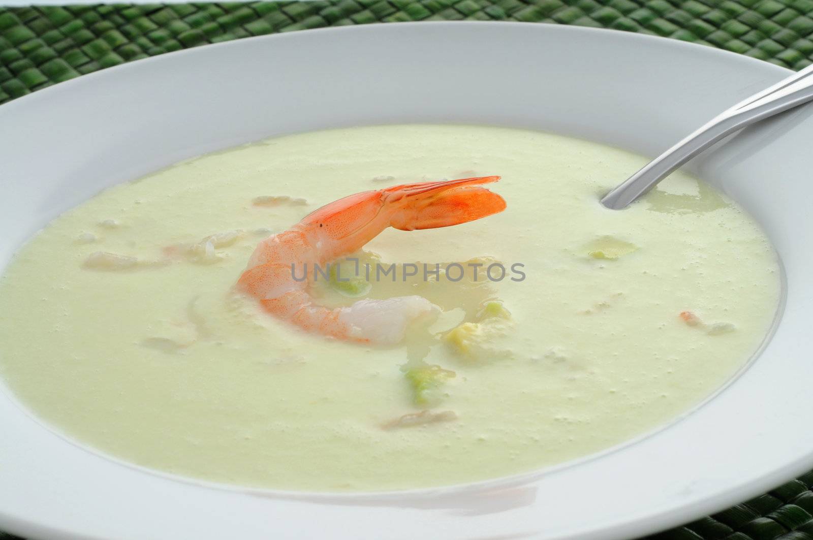 Cold avocado, cucumber and seafood soup in a bowl.