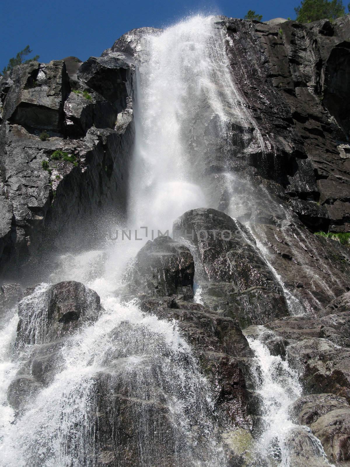 tall nordic waterfall and the blue sky