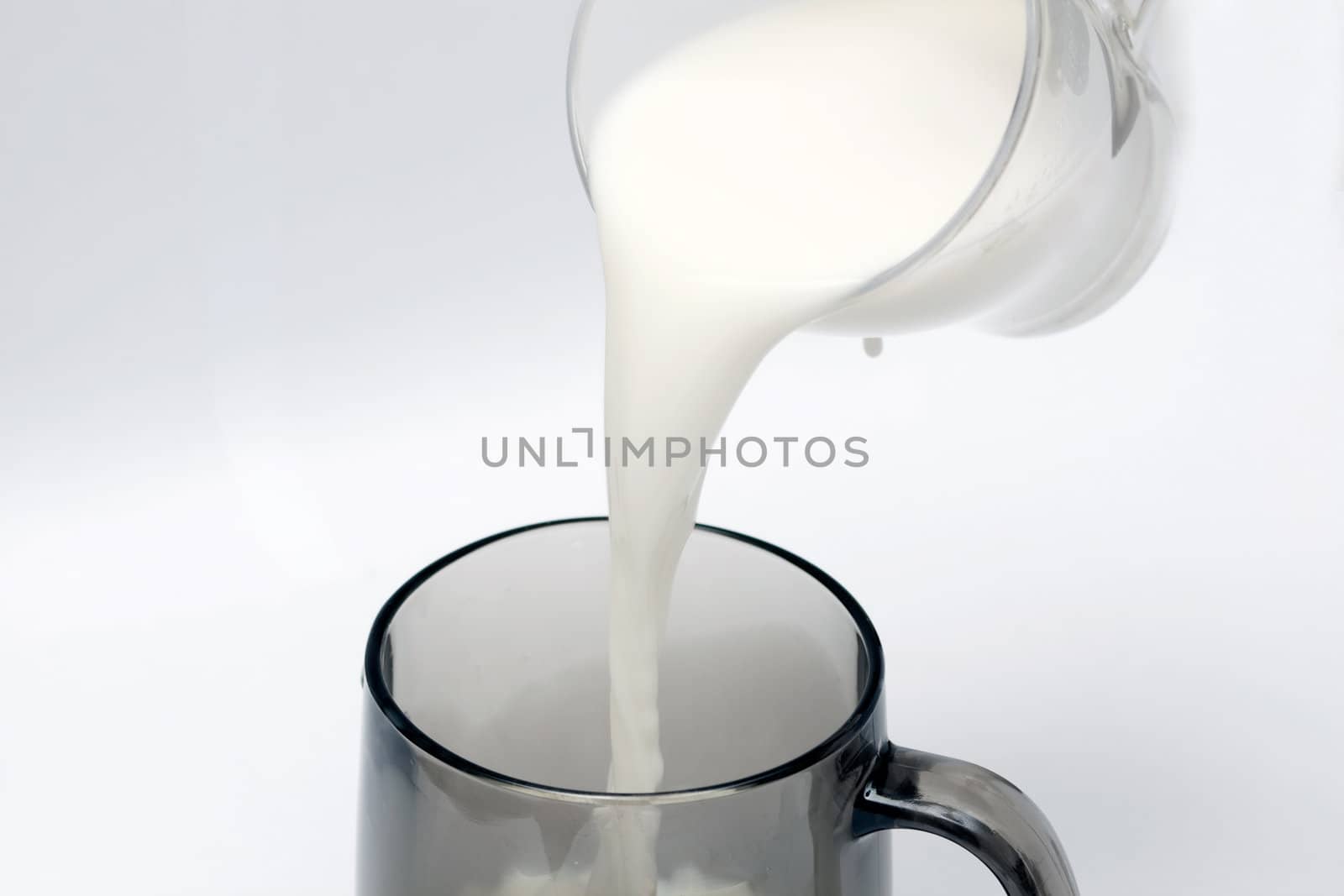 pouring milk to a black glass