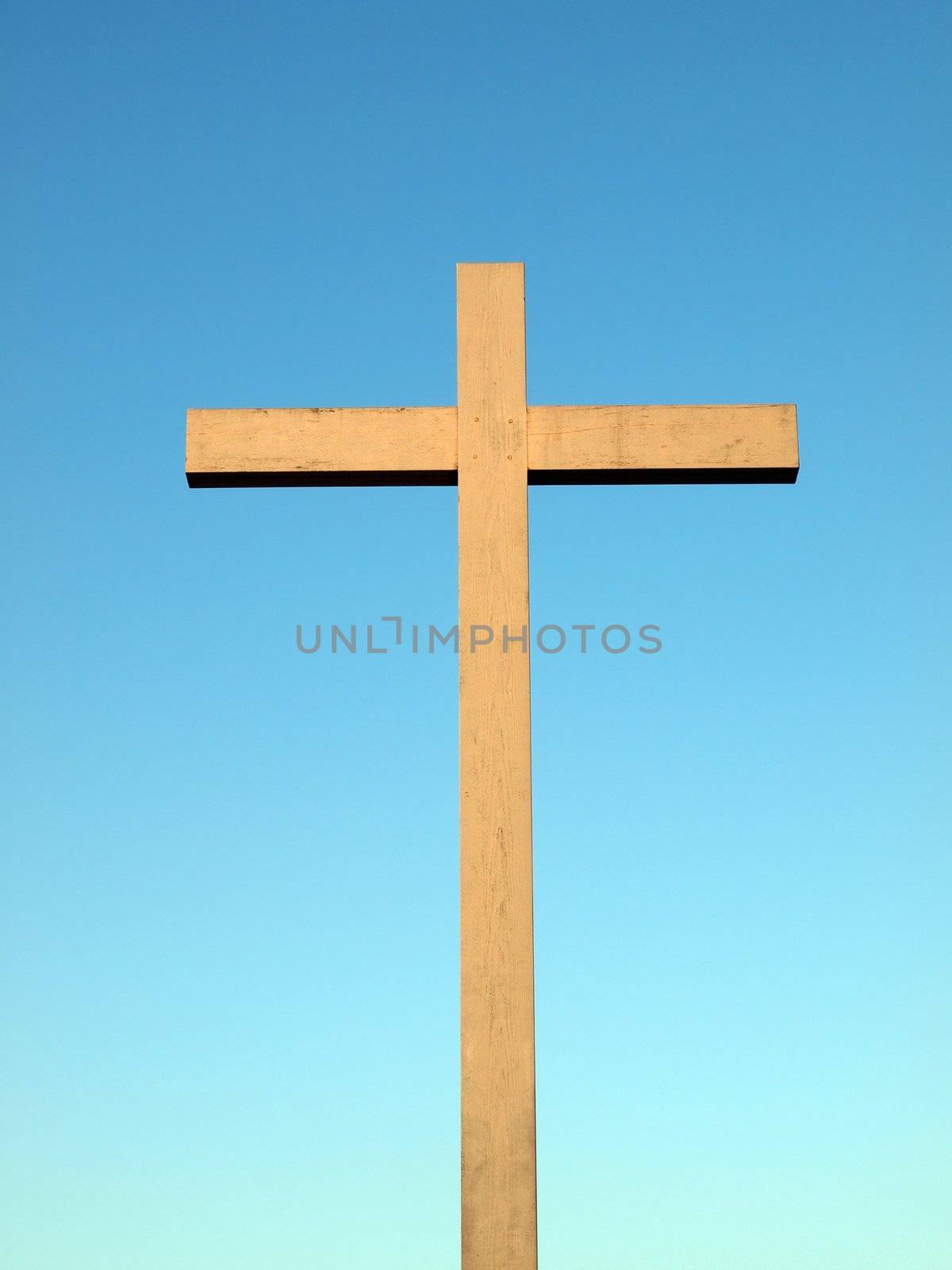 A wooden Christian cross over a blue sky