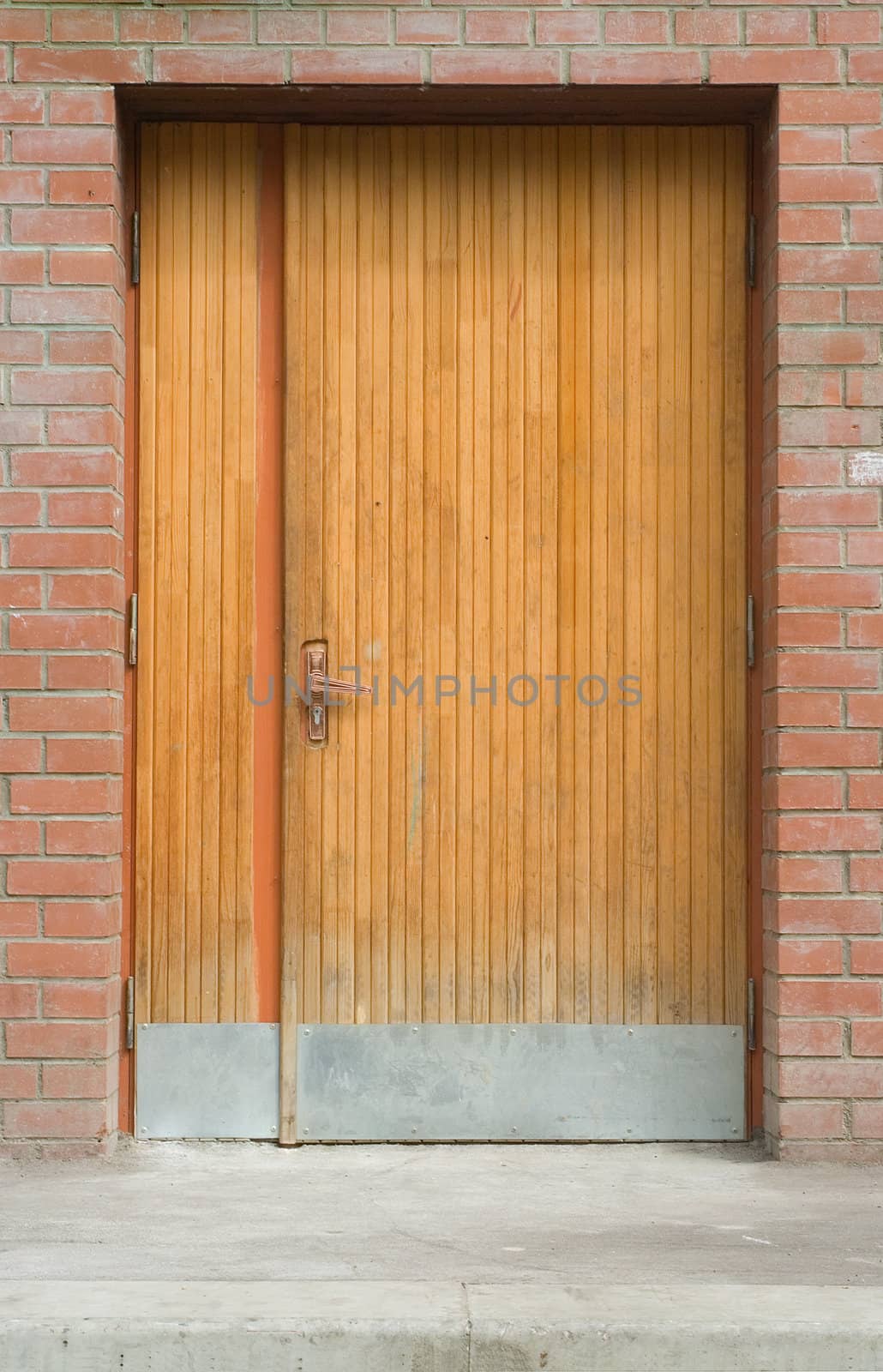 locked old wooden door in a wall of red bricks