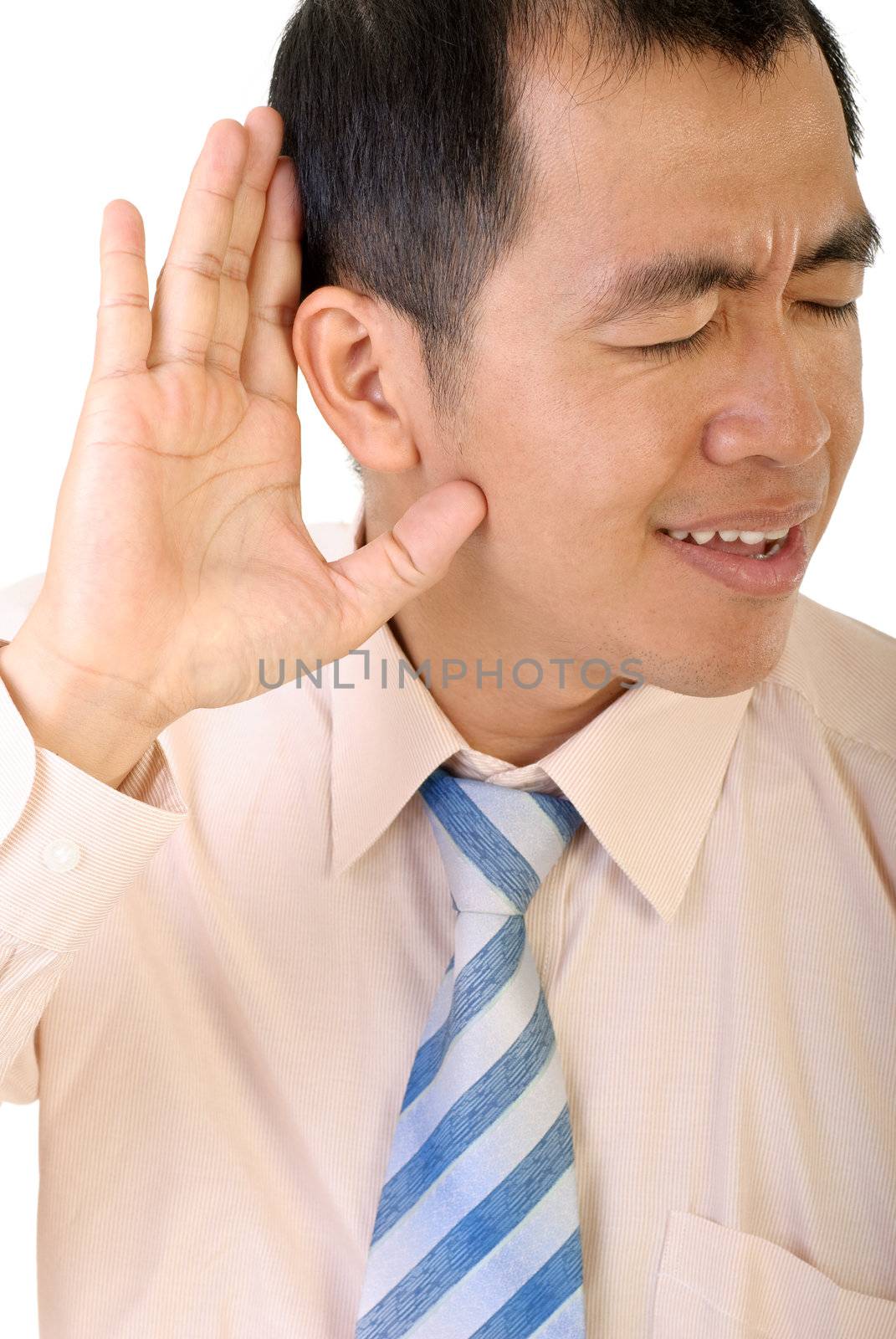 Businessman listen by gesture with his hand to ear to hear on white background.