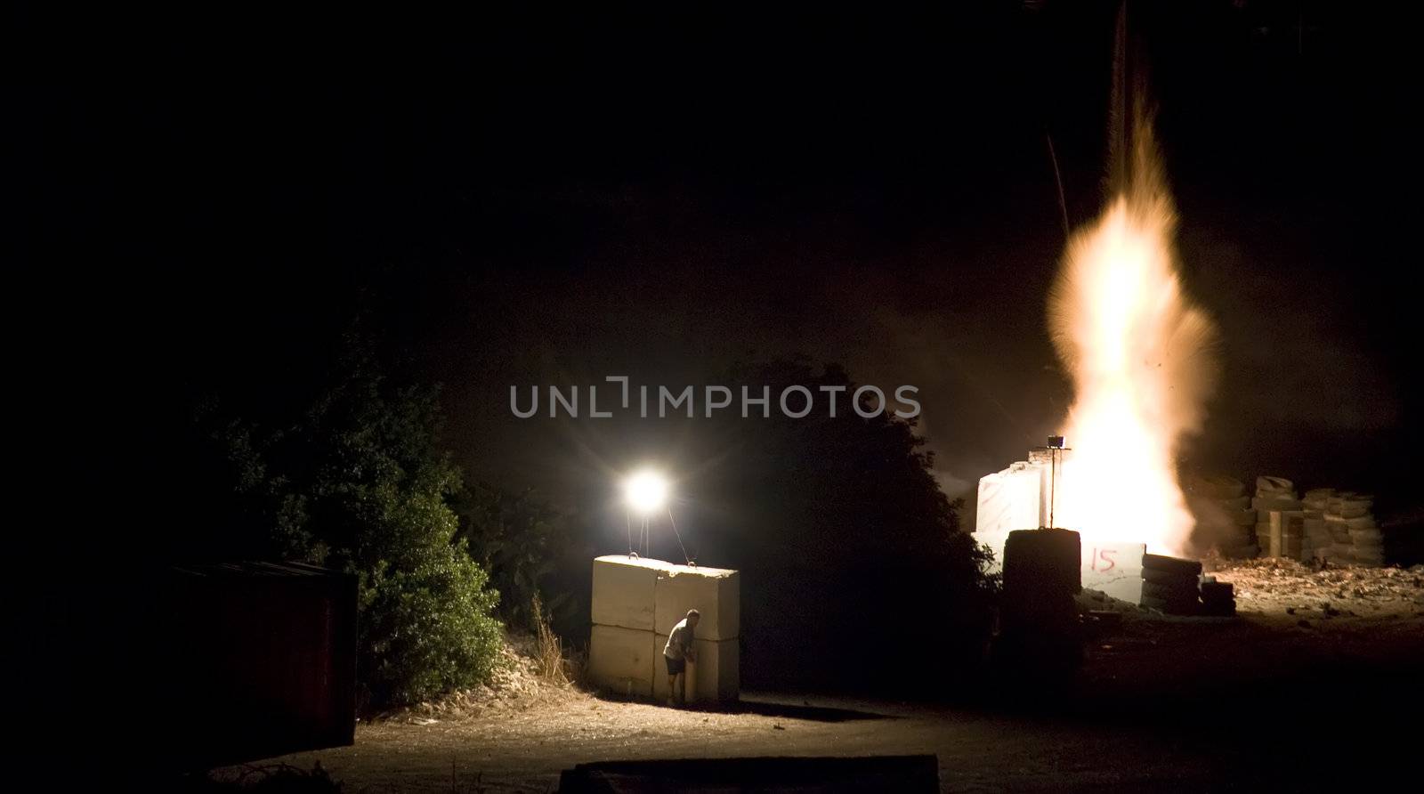 Pyrotechnician taking shelter behind concrete blocks during fuse burnout prior to firework launch Second in series of four