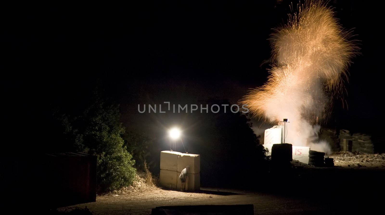 Pyrotechnician taking shelter behind concrete blocks during fuse burnout prior to firework launch Third in series of four