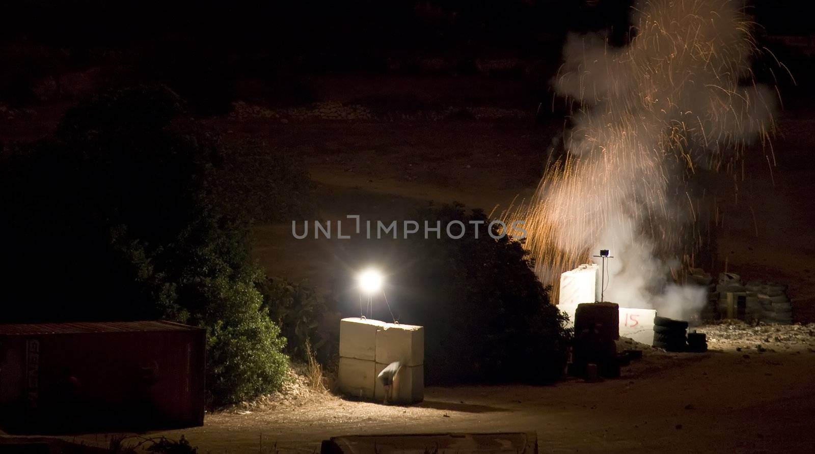 Pyrotechnician taking shelter behind concrete blocks during fuse burnout prior to firework launch Last in series of four