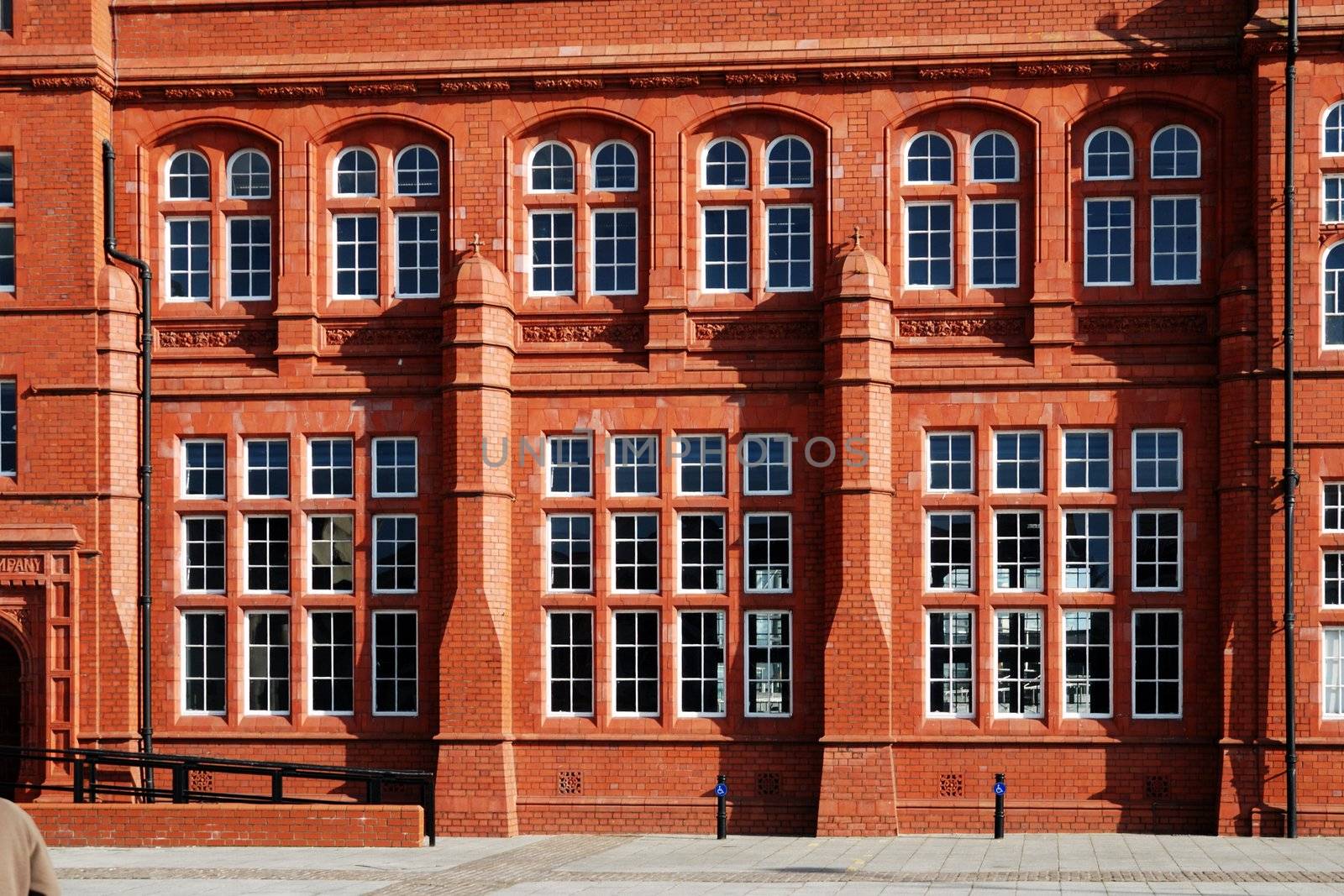 wall of red historical building in cardiff bay with windows