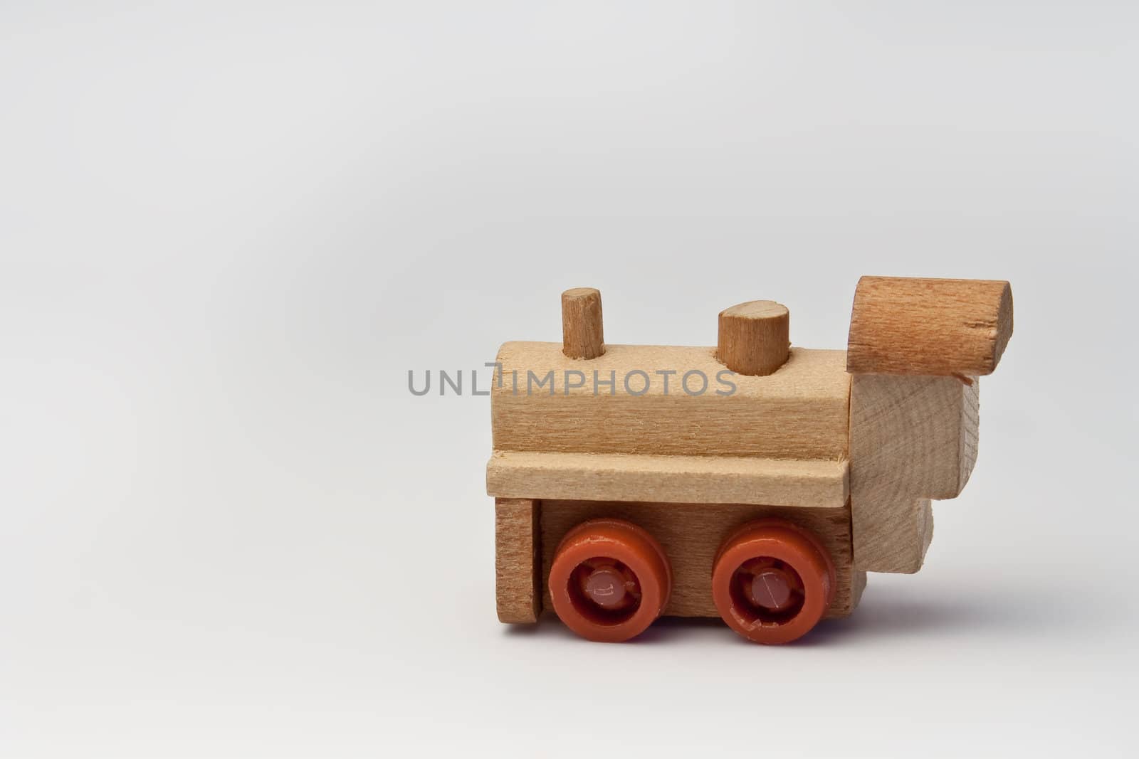 Small wooden toy train on a white background