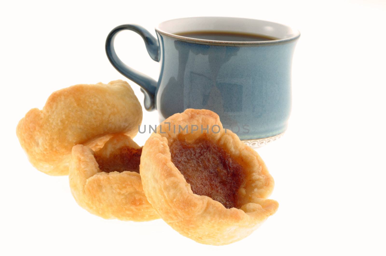 Fresh baked butter tarts with a cup of coffee.