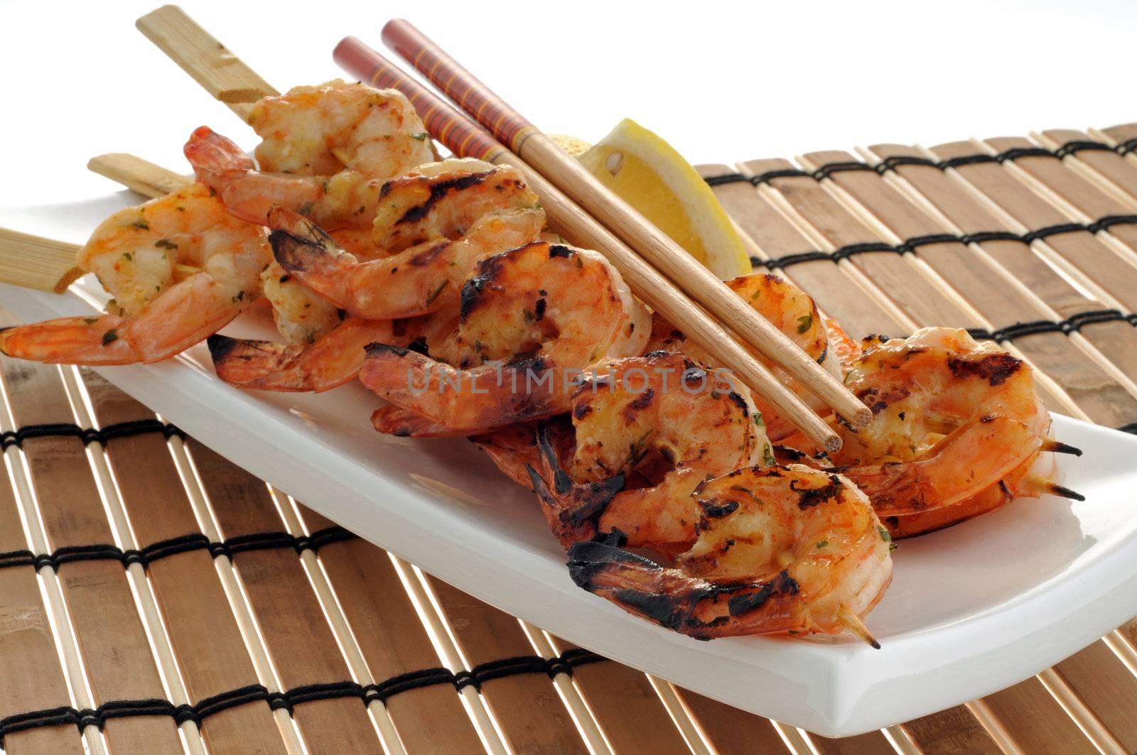 Delicious grilled shrimp served with lemon wedges.